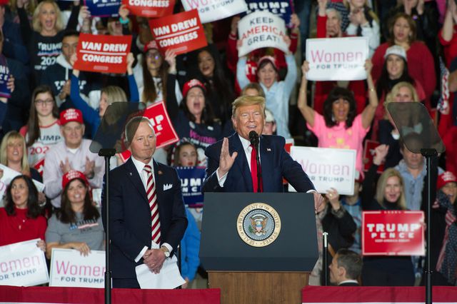 President Donald Trump speaks on a dais in Willdwood, NJ, with Rep. Jeff Van Drew next to him
